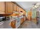 Open kitchen with wood cabinets, dining area, tiled floor, and bright natural light at 407 Howard Tant Rd, Zebulon, NC 27597