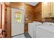 The laundry room features wood walls, a white door to the outside and a washer and dryer at 407 Howard Tant Rd, Zebulon, NC 27597
