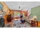Cozy living room with hardwood floors, wood-paneled walls, and a stone fireplace at 407 Howard Tant Rd, Zebulon, NC 27597