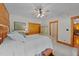 Cozy main bedroom featuring a ceiling fan, painted wood floors, closet, and a decorative wardrobe at 407 Howard Tant Rd, Zebulon, NC 27597
