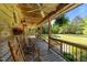 Spacious wrap-around porch with rocking chairs, ceiling fans, and views of the lush green lawn at 407 Howard Tant Rd, Zebulon, NC 27597