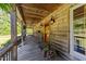 Inviting wrap-around porch featuring wood paneling, rocking chairs, and charming decor at 407 Howard Tant Rd, Zebulon, NC 27597