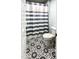 Bathroom with a toilet, vanity, and a shower with stylish patterned tile flooring and a blue and white curtain at 409 Eagle Ct, Henderson, NC 27536