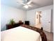 Bedroom with a ceiling fan, dark wood furniture, neutral carpet, and natural light from two windows at 409 Eagle Ct, Henderson, NC 27536