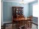 Elegant dining room with beautiful blue wall panelling, and a lovely wood china cabinet at 409 Eagle Ct, Henderson, NC 27536