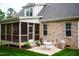 Backyard featuring a screened porch, patio with seating, and a well-manicured lawn with plantings at 409 Eagle Ct, Henderson, NC 27536