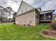 Brick home's exterior with a well-maintained lawn and a screened-in porch, showcasing outdoor living at 409 Eagle Ct, Henderson, NC 27536