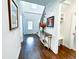 Grand foyer with a staircase, hardwood floors, elegant console table with floral arrangement, and bright, airy lighting at 409 Eagle Ct, Henderson, NC 27536