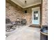Cozy front porch with seating and a view of the front door, all brick, with a welcome mat at 409 Eagle Ct, Henderson, NC 27536