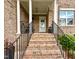 Elegant front porch with brick stairs, white columns, and a glimpse of the front door and well manicured landscape at 409 Eagle Ct, Henderson, NC 27536