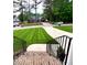 Inviting home exterior showcasing a well-manicured lawn, mature trees, and long driveway at 409 Eagle Ct, Henderson, NC 27536