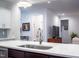 Modern kitchen island with stainless sink overlooks the entry to the living room at 409 Eagle Ct, Henderson, NC 27536