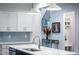 Well-lit kitchen showcasing a quartz island with a stainless sink and gray subway tile backsplash at 409 Eagle Ct, Henderson, NC 27536