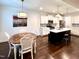 Open kitchen and dining area with island, stainless appliances, white cabinets, and dark hardwood floors at 409 Eagle Ct, Henderson, NC 27536