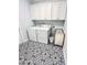 A laundry room featuring ample cabinet space, a washer, a dryer, and stylish patterned tile flooring at 409 Eagle Ct, Henderson, NC 27536