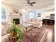 Bright living room featuring a fireplace, neutral-toned sofas, hardwood floors, and open access to the kitchen at 409 Eagle Ct, Henderson, NC 27536