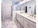 Lovely bathroom featuring double sinks, white cabinets, and a glass-enclosed shower at 409 Eagle Ct, Henderson, NC 27536