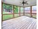 Inviting screened porch with a ceiling fan, offering a comfortable outdoor living space with backyard views at 409 Eagle Ct, Henderson, NC 27536