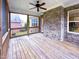 Enclosed screened-in porch with wooden deck and brick accent wall, perfect for relaxing and entertaining outdoors at 409 Eagle Ct, Henderson, NC 27536