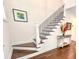 Elegant staircase with wood treads, white risers, black wrought iron railing, and stylish decor at 409 Eagle Ct, Henderson, NC 27536