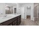 Bathroom featuring double sink vanity with solid surface countertop and tiled shower at 413 Providence Springs Ln, Fuquay Varina, NC 27526