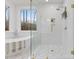 A modern bathroom boasts a luxurious tub, glass enclosed shower with gold hardware, and a calming view of the outdoors at 42 Turkey Ct, Timberlake, NC 27583