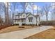 Charming two-story white home with a welcoming front porch, and a long driveway landscaped with pine straw at 42 Turkey Ct, Timberlake, NC 27583