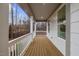 A long open porch with a wooden floor and white railings offers a inviting area with nature views at 42 Turkey Ct, Timberlake, NC 27583