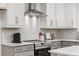 Kitchen boasts stainless steel range hood and herringbone tile backsplash at 42 Turkey Ct, Timberlake, NC 27583