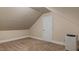 Attic space featuring neutral walls, carpet, a door, and a portable air conditioner at 450 S Stratford Dr, Henderson, NC 27537