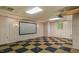 Finished basement features a projector screen and checkered black and gold tile flooring at 450 S Stratford Dr, Henderson, NC 27537