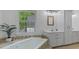 Bathroom with tiled tub, big window, recessed lights, and double sink at 450 S Stratford Dr, Henderson, NC 27537