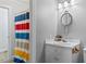 Bathroom featuring a gray sink vanity, round mirror, and a colorful shower curtain at 450 S Stratford Dr, Henderson, NC 27537