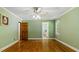 Cozy bedroom featuring hardwood floors, neutral walls, and an adjacent bathroom at 450 S Stratford Dr, Henderson, NC 27537