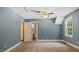 Blue bedroom features neutral carpet, a ceiling fan, and an ensuite bath at 450 S Stratford Dr, Henderson, NC 27537