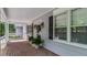 Charming front porch with brick flooring, windows with shutters, and potted plants at 450 S Stratford Dr, Henderson, NC 27537