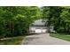 Spacious two-car garage with an extended driveway, surrounded by lush trees and landscaping at 450 S Stratford Dr, Henderson, NC 27537