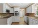 Traditional kitchen with white cabinets, stainless steel appliances, and warm-toned backsplash at 450 S Stratford Dr, Henderson, NC 27537