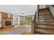 Spacious living room with fireplace, stairs, hardwood floors, and access to balcony at 450 S Stratford Dr, Henderson, NC 27537