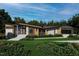 Contemporary home with stone and wood exterior, modern windows, landscaped yard, and unique roofline against a blue sky at 481 Brook Green Ln # 23, Pittsboro, NC 27312
