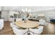 A stylish dining area with a wooden table and six chairs open to the kitchen and living room with a neutral palette at 5009 Megara, Raleigh, NC 27603