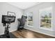 Bright home gym with exercise equipment, including a bike and treadmill, plus natural light from two windows at 5009 Megara, Raleigh, NC 27603