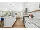 An open-concept kitchen with a granite island, white cabinets, stainless steel appliances, and hardwood floors at 5009 Megara, Raleigh, NC 27603