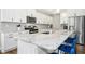 A kitchen island with white cabinets, stainless steel appliances, granite countertops, and blue barstools at 5009 Megara, Raleigh, NC 27603