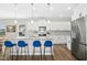 Kitchen with an island featuring granite countertops, stainless steel appliances, and stylish blue barstools at 5009 Megara, Raleigh, NC 27603
