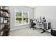 A home office with a large window, a modern desk setup with dual monitors, and a bookshelf at 5009 Megara, Raleigh, NC 27603