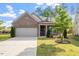 Charming brick home featuring an attached garage and a beautifully landscaped front yard with lush green grass at 52 Brunello Ct, Clayton, NC 27527