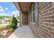 Inviting front porch with brick facade, landscaped yard, and partial view of neighborhood at 52 Brunello Ct, Clayton, NC 27527