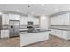 Stylish kitchen featuring white cabinets, stainless steel appliances, granite countertops, and an island with a breakfast bar at 52 Brunello Ct, Clayton, NC 27527