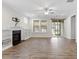 Comfortable living room showcasing a fireplace with built-in shelves, natural light from large windows, and ceiling fan at 52 Brunello Ct, Clayton, NC 27527